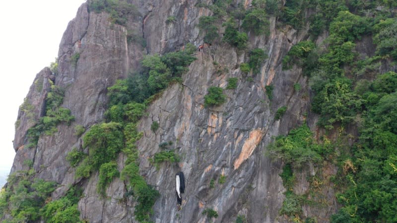 BASE jumper hangs from his parachute at Khao Thalu cliff in Phatthalung