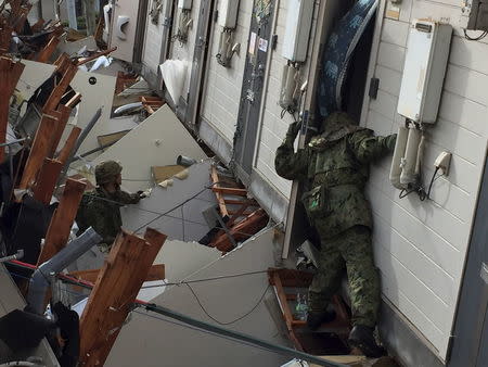Japan Ground Self-Defense Force soldiers conduct search and rescue operations at an apartment which collapsed following an earthquake in Minamiaso town, Kumamoto prefecture, southern Japan, in this handout photo released by the Joint Staff of the Defence Ministry of Japan and taken April 17, 2016. REUTERS/Joint Staff of the Defence Ministry of Japan/Handout via Reuters