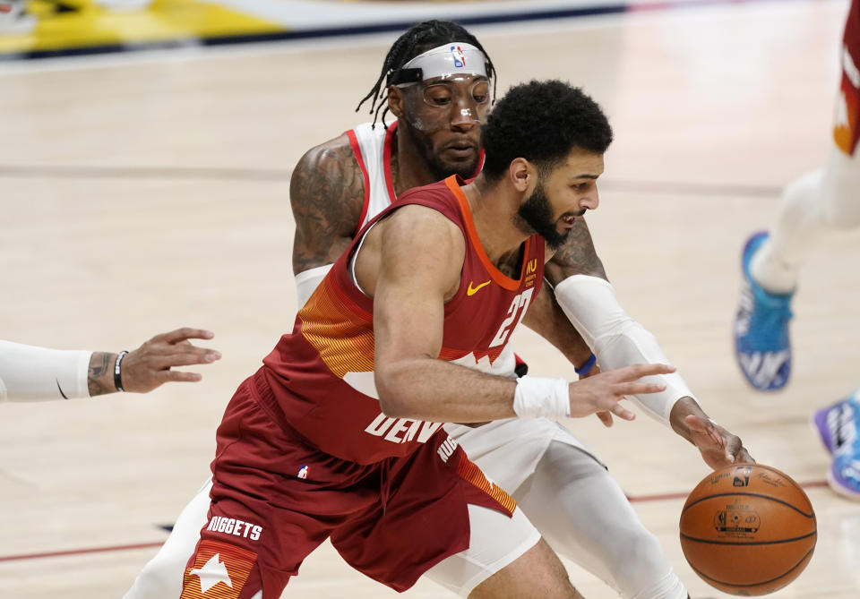 Denver Nuggets guard Jamal Murray, front, loses control of the ball as Portland Trail Blazers forward Robert Covington defends in the first half of an NBA basketball game on Tuesday, Feb. 23, 2021, in Denver. (AP Photo/David Zalubowski)