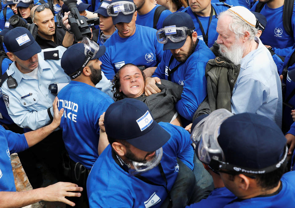 Israeli policemen remove a pro-settlement activist during an operation by Israeli forces to evict residents from several homes in the Israeli settlement of Ofra, in the occupied West Bank