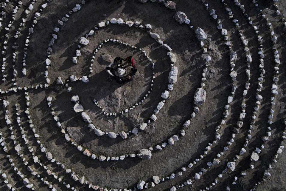 Un grupo de turistas brasileños se dan la mano en círculo en el corazón de un laberinto de piedras en el parque temático espiritual Pueblo Encanto en Capilla del Monte, Argentina, el 19 de julio de 2023. En la patria del papa Francisco, Argentina, algunos católicos han renunciado a la fe y se han sumado a las crecientes filas de los no afiliados religiosamente. Conocidos como “nones” —que puede traducirse como “ninguna”, por “ninguna religión”— se identifican como ateos, agnósticos, espirituales pero no religiosos o, simplemente, nada en particular. (AP Foto/Natacha Pisarenko)