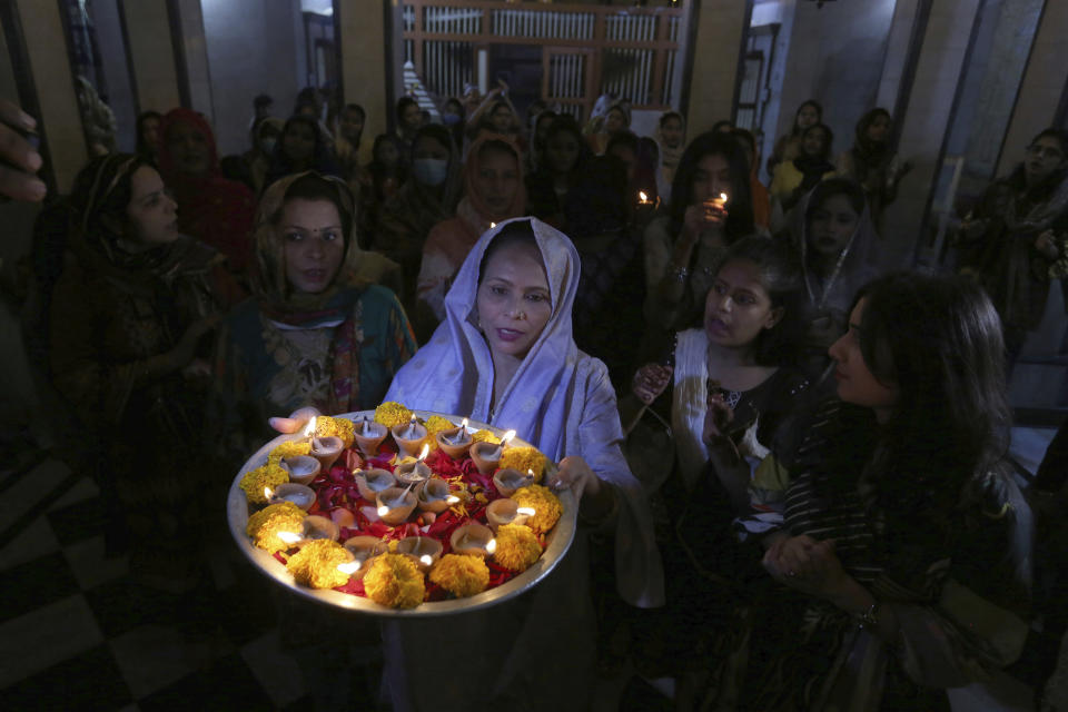 Hindu women attend a ceremony to celebrate Diwali, the festival of lights, at Swami Narayan temple in Karachi, Pakistan, Saturday, Nov. 14, 2020. The Hindu festival of lights, Diwali celebrates the spiritual victory of light over darkness. (AP Photo/Fareed Khan)