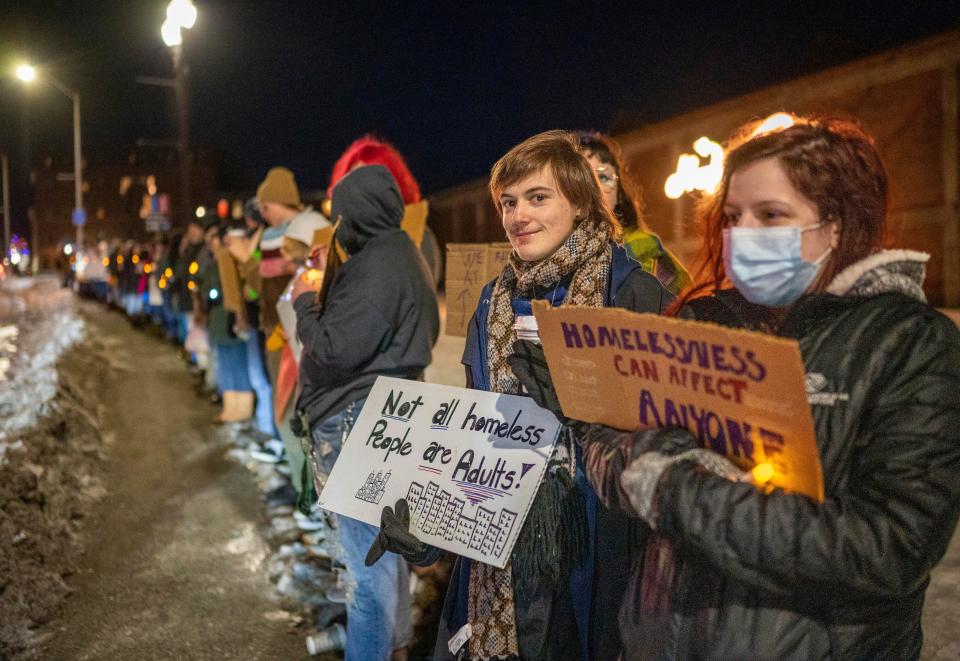 Adam Champiuon and Michelle McIntyre, right, hold signs in December at a vigil that is part of a national movement of cities marking National Homeless Persons' Memorial Day in Lewiston, Maine.