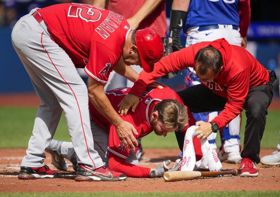 Taylor Ward #3 of the Los Angeles Angels is helped after being hit by a pitch in Toronto on July 29.