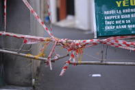 A ladder is used to make barricade in an alley in Vung Tau, Vietnam, Monday, Sept. 20, 2021. The roadblocks and barricades make the streets of this southern Vietnamese city look like they did during the war that ended almost 50 years ago. But this time, the battle is being fought against the rampaging coronavirus.(AP Photo/Hau Dinh)