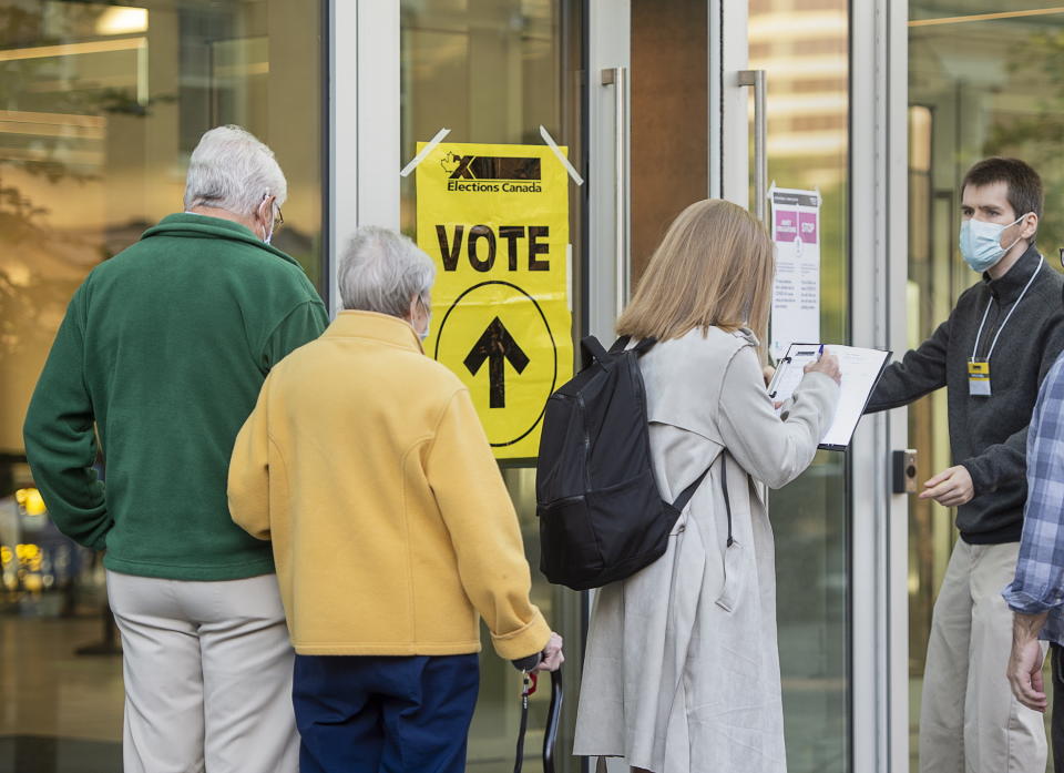 A voter provides COVID-19 contact-tracking information at the Halifax Convention Centre as they prepare to vote in the federal election in Halifax on Monday, Sept. 20, 2021. (Andrew Vaughan/The Canadian Press via AP)