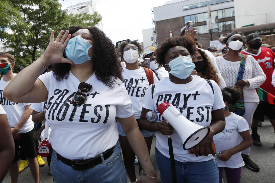 Women shout during a Pray and Protest rally and march, Sunday, June 7, 2020, in the Bedford-Stuyvesant neighborhood of the Brooklyn borough of New York. The protest was held in the wake of the May 29 death of George Floyd while in the custody of four police officers in Minneapolis. (AP Photo/Kathy Willens)