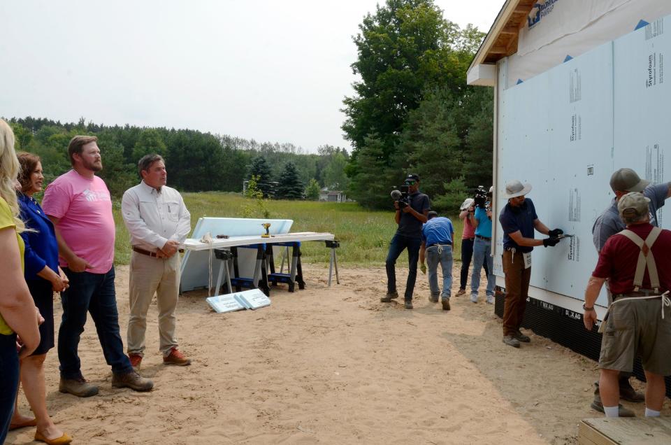 Gov. Gretchen Whitmer and other officials watch as work is done on a home on Tuesday, Aug. 1, 2023 in the Meadowlands neighborhood.