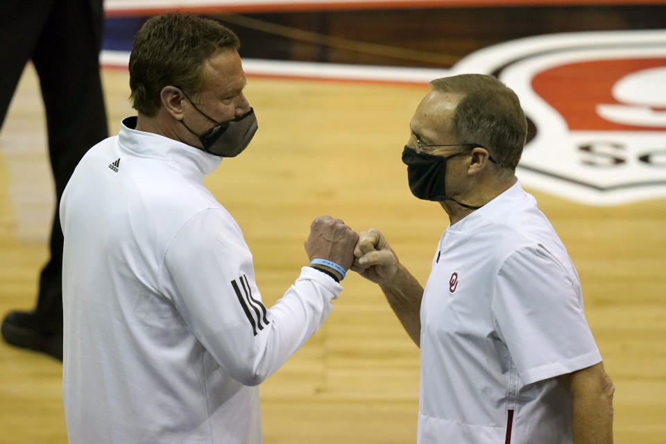 Kansas head coach Bill Self, left, fist bumps Oklahoma head coach Lon Kruger, right, following an NCAA college basketball game in the quarterfinal round of the Big 12 men's tournament in Kansas City, Mo., Thursday, March 11, 2021. Kansas defeated Oklahoma 69-62. (AP Photo/Orlin Wagner)