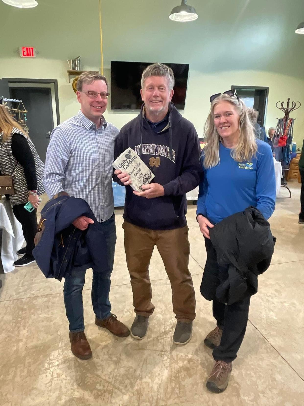 South Bend Mayor James Mueller, left, Ken Bradford and Sarah Stewart gather for a recent Earth Day event at the Unity Gardens on Prast Avenue in South Bend. Bradford was honored with a Green Globe Award for his service to the garden and volunteering for 10 years.