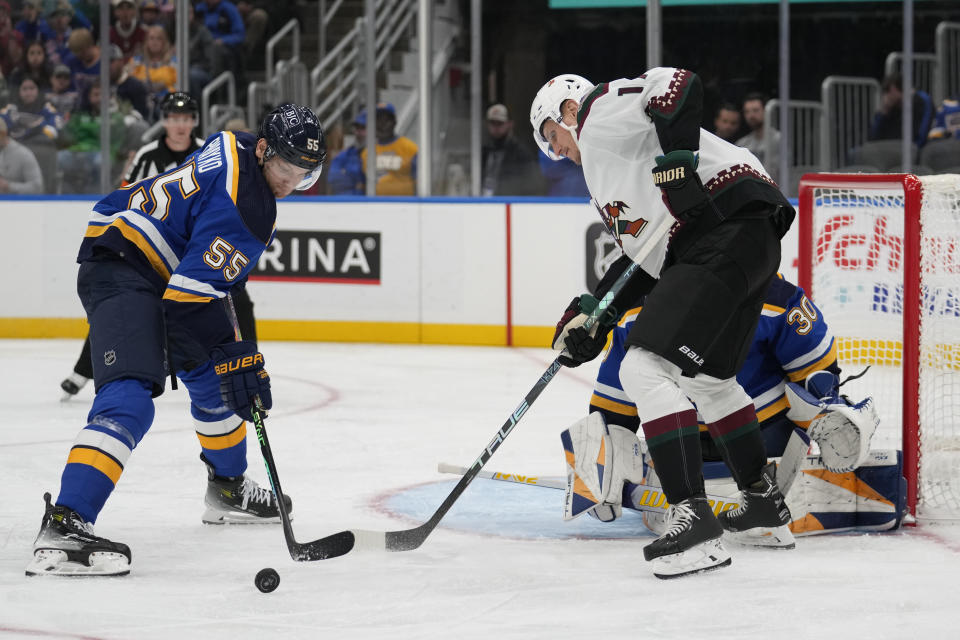 St. Louis Blues' Colton Parayko (55) and Arizona Coyotes' Nick Bjugstad battle for a loose puck during the third period of an NHL hockey game Thursday, Oct. 19, 2023, in St. Louis. (AP Photo/Jeff Roberson)