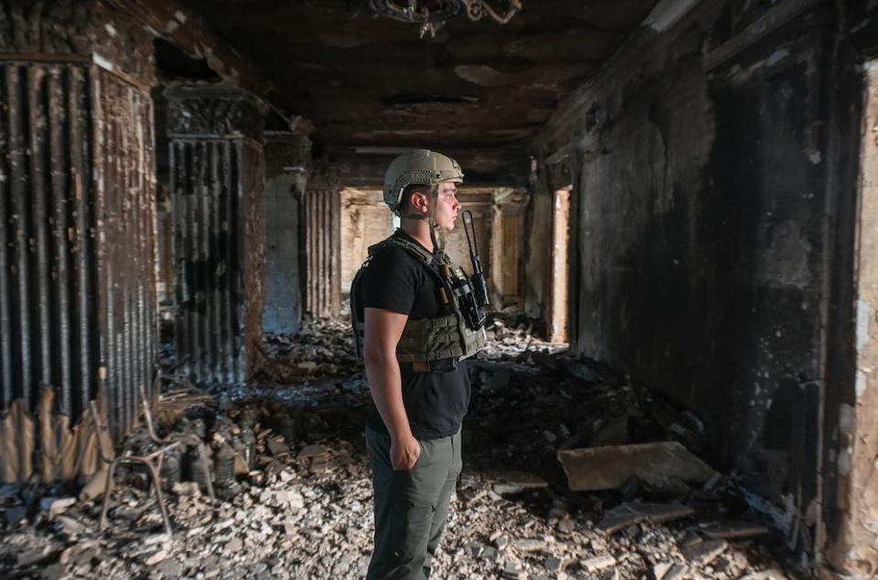 A young soldier, one of our military escorts in Chasiv Yar, looking out into the destroyed theater in his hometown.