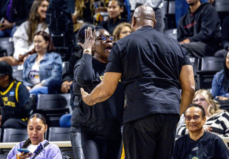 Comedian Leslie Jones hugs Magic Johnson during the Sparks season opener