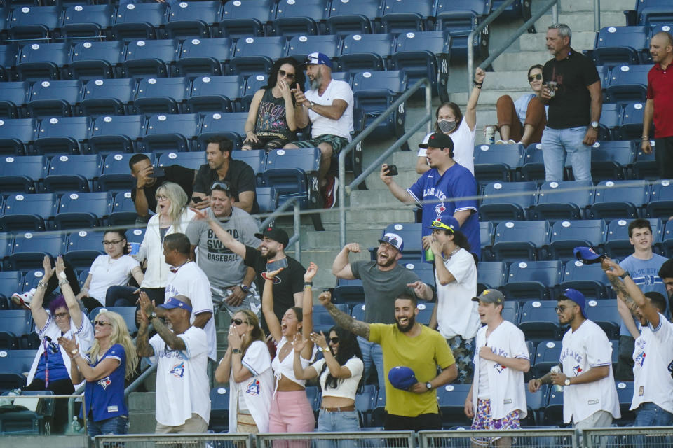 Relatives and loved ones of Toronto Blue Jays' Alek Manoah cheer during the fifth inning of the first game of a baseball doubleheader against the New York Yankees Thursday, May 27, 2021, in New York. (AP Photo/Frank Franklin II)