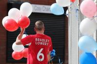 <p>People line the route of the funeral procession with decorations ahead of the funeral of Bradley Lowery, the six-year-old football mascot whose cancer battle captured hearts around the world </p>