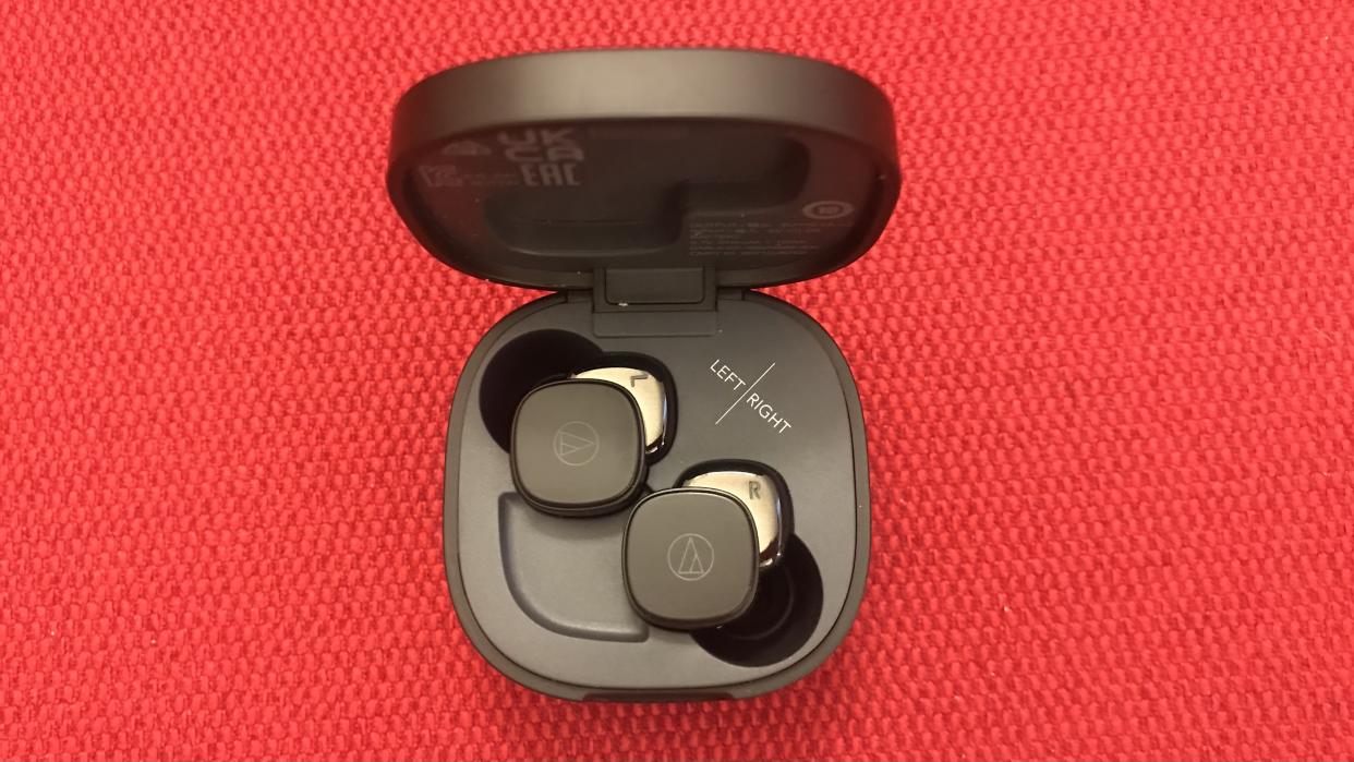  Audio-Technica ATH-SQ1TW earbuds and case on red backgound. 