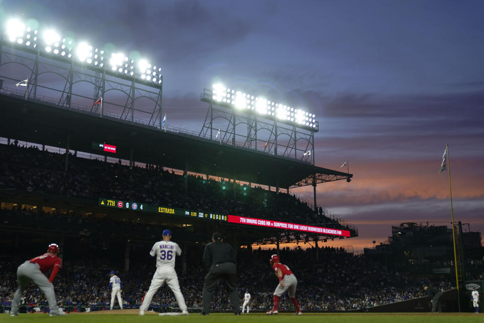 The sun sets behind the bleachers during the seventh inning of a baseball game between the Cincinnati Reds and Chicago Cubs, Saturday, May 27, 2023, in Chicago. (AP Photo/Erin Hooley)