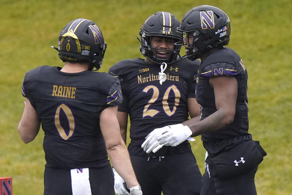 Northwestern wide receiver Kyric McGowan, right, celebrates with tight end John Raine, left, and running back Cam Porter after scoring a touchdown during the first half of an NCAA college basketball game against Illinois in Evanston, Ill., Saturday, Dec. 12, 2020. (AP Photo/Nam Y. Huh)