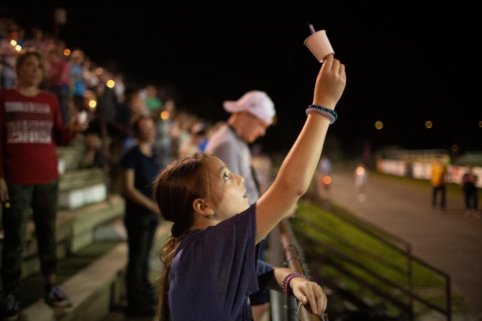 Hannah Childs, a student at Battle Creek Middle School, holds a candle to the sky after blowing it out during a vigil for Battle Creek Middle School sixth-grader Kailee Grace Warren at Spring Hill High School in Spring Hill, Tenn., on Wednesday, Oct. 13, 2021.