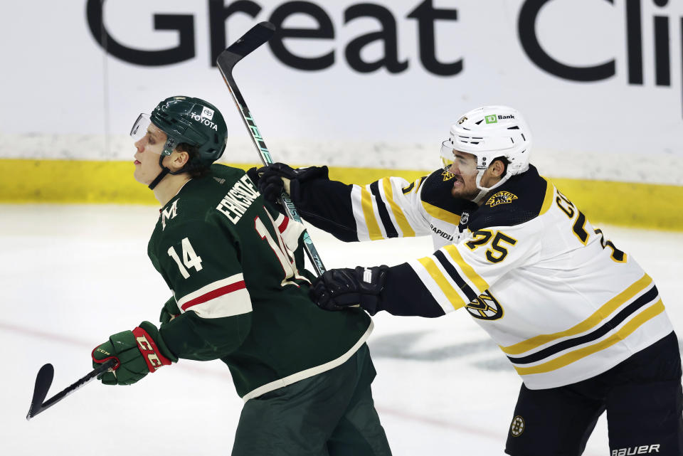 Boston Bruins defenseman Connor Clifton (75) shoves Minnesota Wild center Joel Eriksson Ek (14) during the third period of an NHL hockey game Sunday, March 18, 2023, in St. Paul, Minn. Boston won 5-2. (AP Photo/Stacy Bengs)