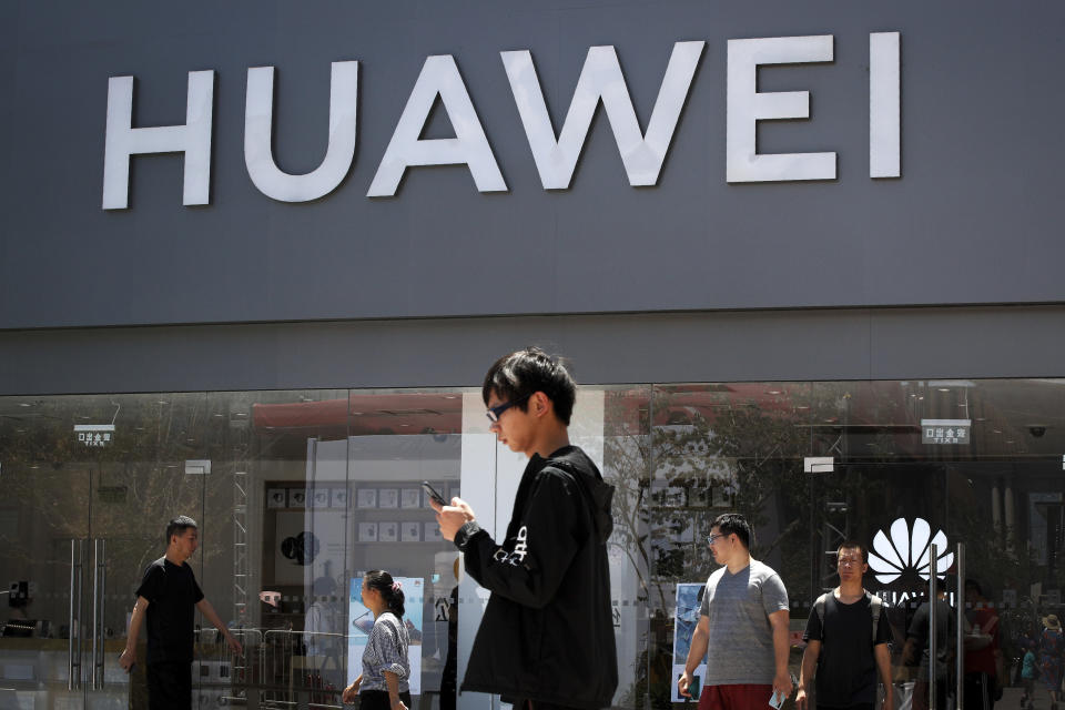 Unas personas pasan enfrente de una tienda de Huawei en Beijing, el domingo 30 de junio del 2019. (AP Foto/Andy Wong)