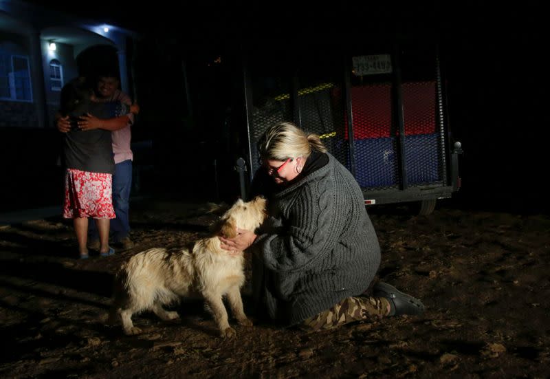 Laura Garcia hugs her dog after arriving home, in Jalpan de Serra