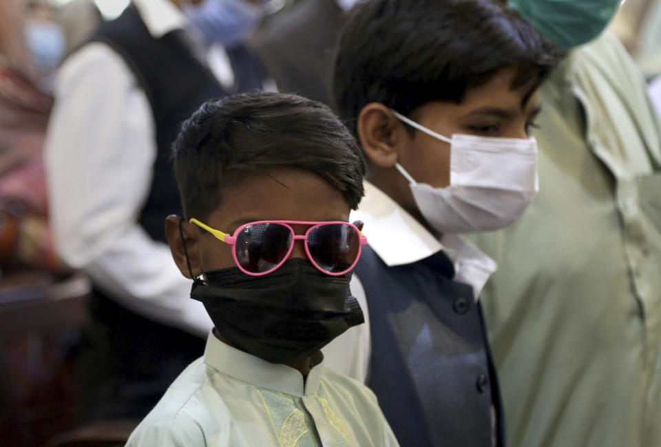 A Christian boy attends an Easter mass with others the a St. John's Cathedral, in Peshawar, Pakistan, Sunday, April 4, 2021. (AP Photo/Muhammad Sajjad)