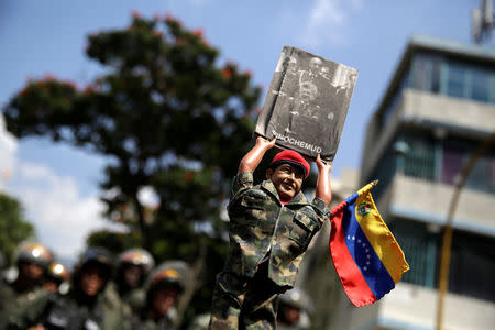 A doll depicting Venezuela's late President Hugo Chavez is seen as Supporters of Venezuela's President Nicolas Maduro gather outside the National Assembly building during a session in Caracas, Venezuela October 27, 2016. REUTERS/Marco Bello