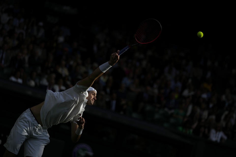 John Isner of the US serves to Britain's Andy Murray during their singles tennis match on day three of the Wimbledon tennis championships in London, Wednesday, June 29, 2022. (AP Photo/Alastair Grant)
