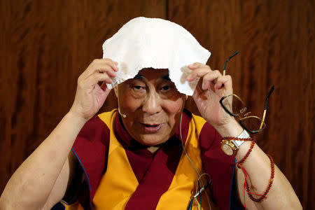 FILE PHOTO: Tibet's exiled spiritual leader the Dalai Lama puts a towel on his head during a news conference in Paris, France, September 13, 2016. REUTERS/Charles Platiau/File Photo