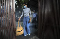 A model gets herself sanitized before entering the office of the Fashion Development Corporation of India (FDCI) in preparation for the Lotus make-up India Fashion week digital show in New Delhi, India, Friday, Oct. 2, 2020. India’s first digital fashion week is being held from Oct. 14-18, live streaming the spring-summer collections by more than 40 fashion designers under the banner of Lotus Make-up India Fashion Week. Not to miss the October deadline, the FDCI converted parts of its office building into a studio in a bustling industrial area of Delhi. It created a stage, screens and bespoke lighting to facilitate shooting of fashion films and videos by the designers. (AP Photo/Manish Swarup)