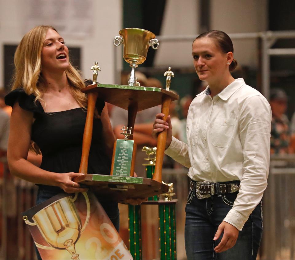 Emma Townsend presents Kennedy Gould with the trophy for winning the Livestock Showmanship Contest, Thursday, July 21, 2022, at the Tippecanoe County 4-H Fairgrounds in Lafayette, Ind.