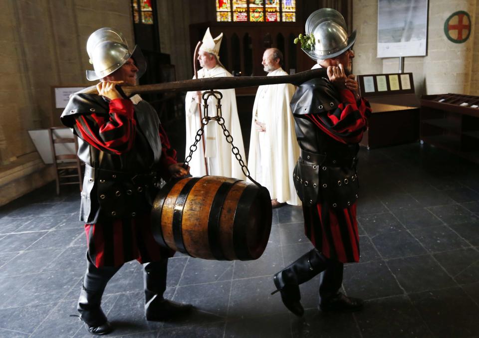 Members of the Knighthood of the Brewers' Mash staff carry a barrel of beer inside the Sint-Gudule Cathedral in Brussels