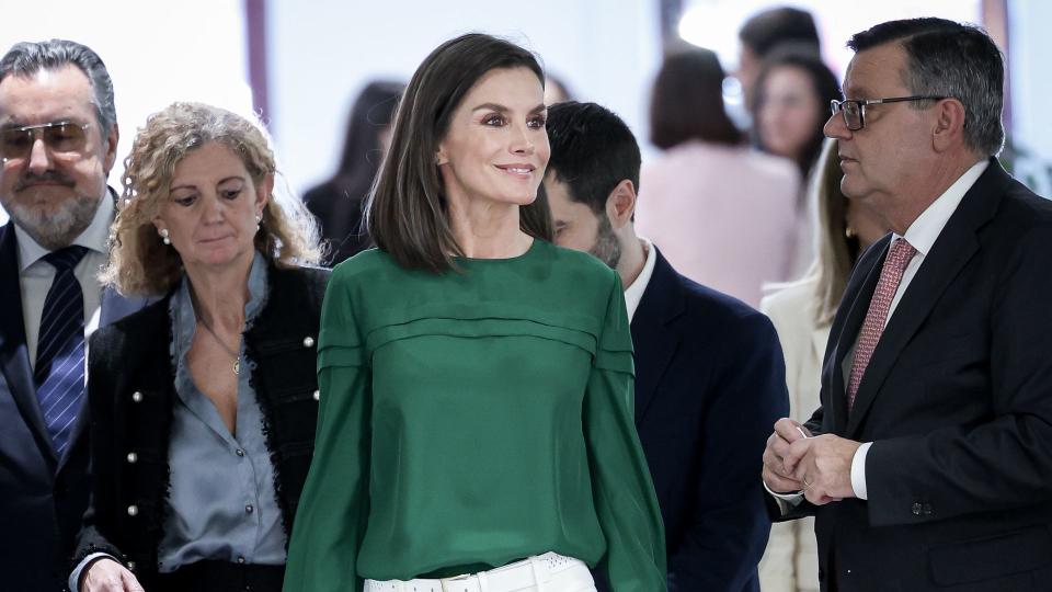 Queen Letizia walking in white trousers and green top