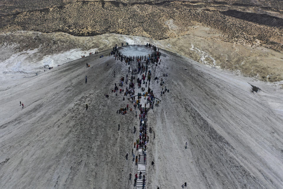 In this aerial photo taken from a drone, Hindu devotees climb stairs to reach on top of a mud volcano to start Hindu pilgrims religious' rituals for an annual festival in an ancient cave temple of Hinglaj Mata in Hinglaj in Lasbela district in Pakistan's southwestern Baluchistan province, Friday, April 26, 2024. More than 100,000 Hindus are expected to climb mud volcanoes and steep rocks in southwestern Pakistan as part of a three-day pilgrimage to one of the faith's holiest sites. (AP Photo/Mohammad Farooq)