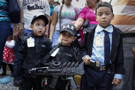 Children dressed as police officers attend a parade during the Carnival festival in Caracas March 4, 2014. REUTERS/Carlos Garcia Rawlins