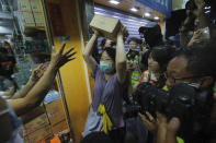 A protester throws a box of goods at a store that sells to mainland customers, in Hong Kong, Saturday, July 13, 2019. Several thousand people marched in Hong Kong on Saturday against traders from mainland China in what is fast becoming a summer of unrest in the semi-autonomous Chinese territory. (AP Photo/Kin Cheung)