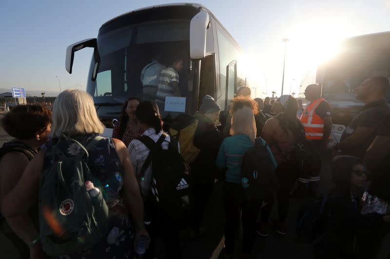 U.S. citizens board a bus at Limassol port after their evacuation from Haifa in Israel, in Limassol