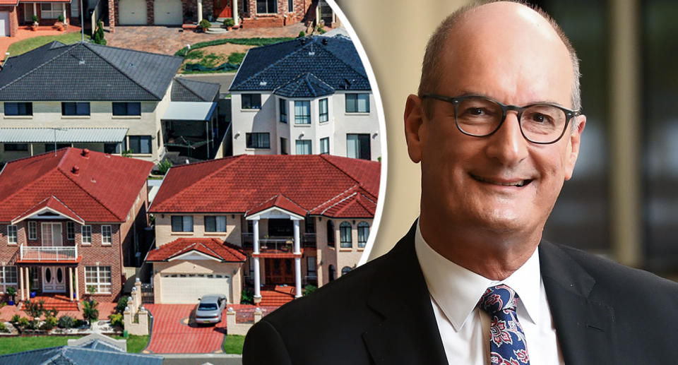 David Koch in a suit with houses behind him.