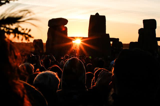 <p>paul mansfield photography/Getty</p> Crowds celebrate the summer solstice at Stonehenge in England in June 2018.