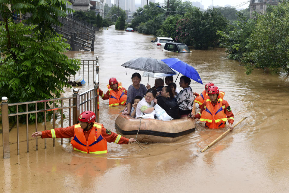 Rescuers evacuate residents on a raft through flood waters in Jiujiang in central China's Jiangxi province Wednesday, July 8, 2020. Rescuers in central China were searching Wednesday for people left missing in a landslide triggered amid widespread flooding across much of the country. (Chinatopix Via AP)