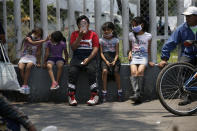 Children wait for a meal from the mobile dining rooms program as people who have not been able to work because of the COVID-19 pandemic line up for a meal outside the Iztapalapa hospital in Mexico City, Wednesday, May 20, 2020. (AP Photo/Marco Ugarte)