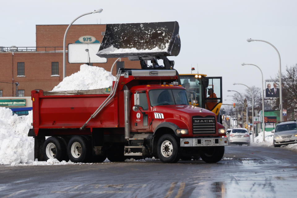 A front end loader dump snow into a dump truck as crews clear large amounts of snow, Wednesday, Dec. 28, 2022, in Buffalo N.Y., days after a winter storm passed through. (AP Photo/Jeffrey T. Barnes)