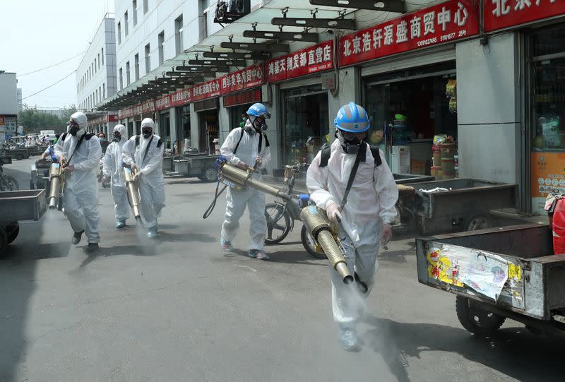 Volunteers from Blue Sky Rescue team disinfect the Yuegezhuang wholesale market in Beijing