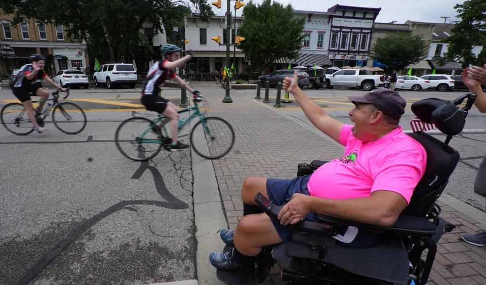 Craig Washka cheers on 2022 Pelotonia riders Saturday as they pass through downtown Granville. Washka founded Craig's Crankers, a cycling group.