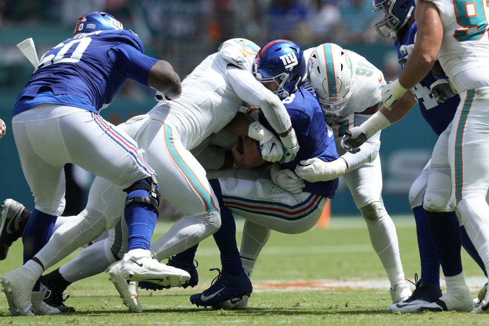 New York Giants quarterback Daniel Jones (8) is sacked by Miami Dolphins defensive end Emmanuel Ogbah (91) and linebacker Bradley Chubb during the first half of an NFL football game, Sunday, Oct. 8, 2023, in Miami Gardens, Fla. (AP Photo/Rebecca Blackwell)