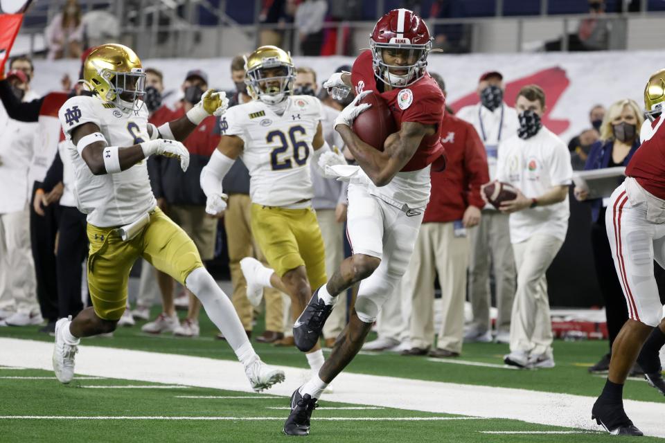 FILE - Alabama wide receiver DeVonta Smith (6) gets past Notre Dame linebacker Jeremiah Owusu-Koramoah (6) and cornerback Clarence Lewis (26) on his way to the end zone for a touchdown in the first half of the Rose Bowl NCAA college football game in Arlington, Texas, in this Friday, Jan. 1, 2021, file photo. The Heisman Trophy winner caught seven passes for 130 yards and three touchdowns as No. 1 Alabama beat No. 4 Notre Dame in a College Football Playoff semifinal.(AP Photo/Michael Ainsworth, File)