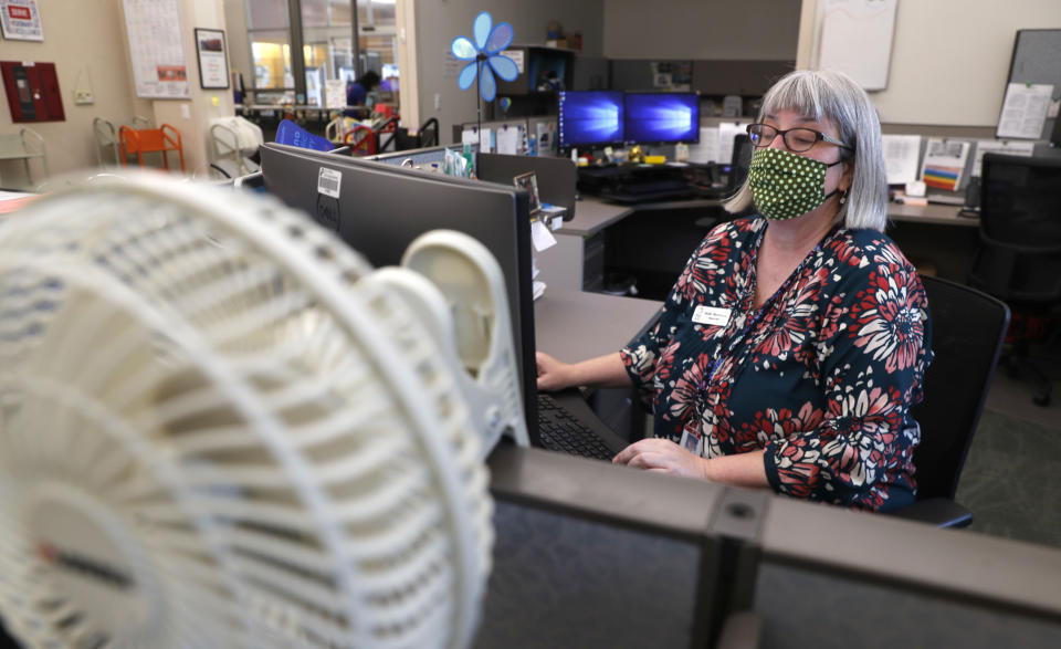 Librarian Holly Ryckman looks up the phone number for 81-year-old Dell Kaplan before calling her in Plano, Texas Friday, May 15, 2020. Ryckman is participating in a program that have popped up across the U.S. during the pandemic to help older adults with a simple offer to engage in small talk. Ryckman said the calls have been "a gift" for her. (AP Photo/LM Otero)