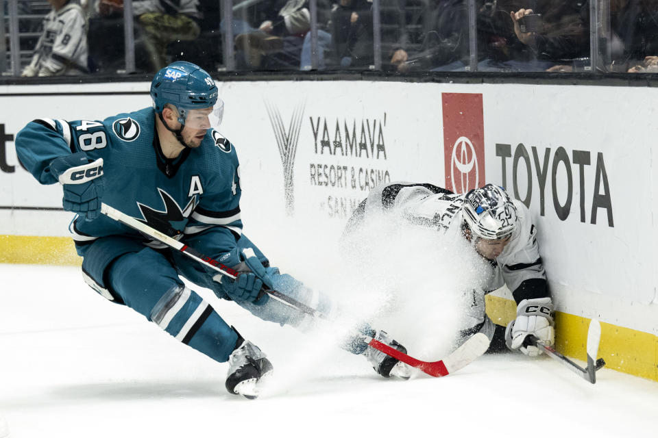 Los Angeles Kings defenseman Jordan Spence (21) and San Jose Sharks center Tomas Hertl (48) vie for the puck during the third period of an NHL hockey game Wednesday, Dec. 27, 2023, in Los Angeles. (AP Photo/Kyusung Gong)