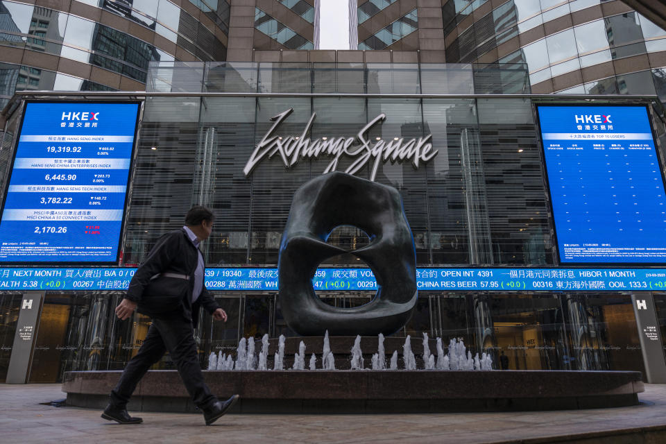 A pedestrian passes by the Hong Kong Stock Exchange electronic screen in Hong Kong on Monday, March 13, 2023. Asian shares mostly fell Monday, shaken by a Wall Street tumble that set off worries the biggest U.S. bank failure in nearly 15 years might have ripple effects around the world. (AP Photo/Louise Delmotte)